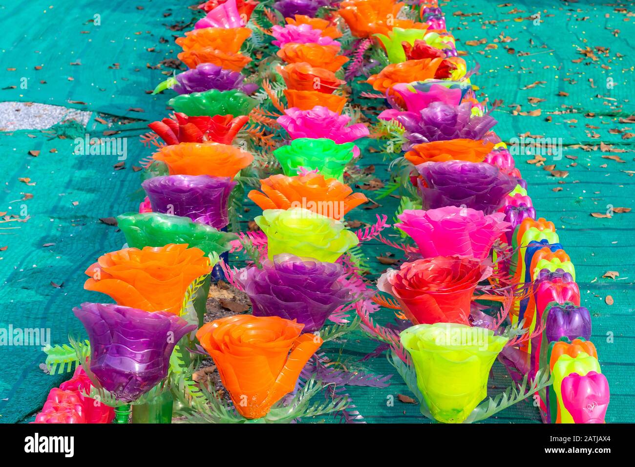 Flores de plástico de colores reciclados hechas de botellas de plástico  para decorar como flores en el jardín. Botella de plástico reciclada  Fotografía de stock - Alamy
