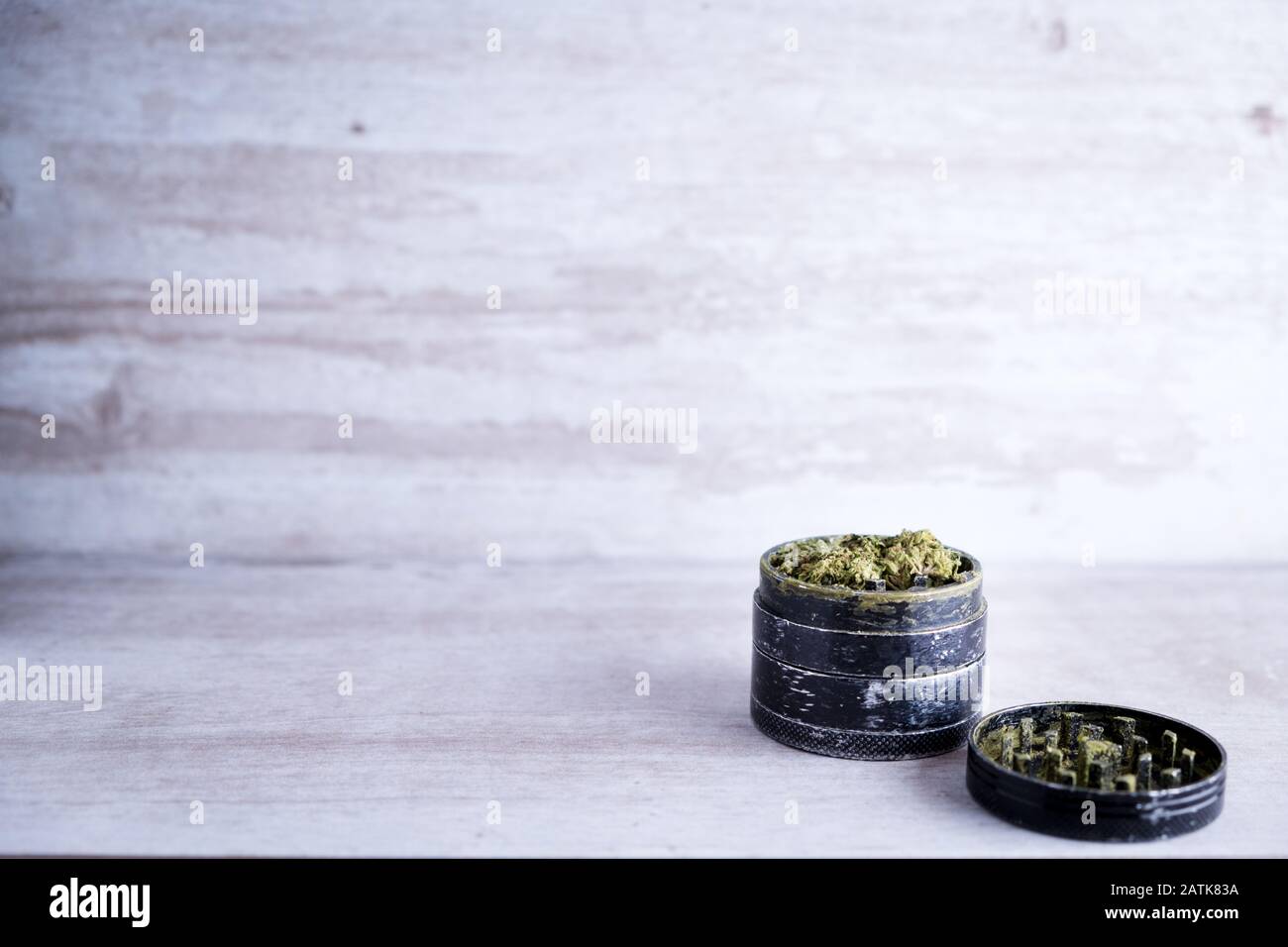 Marihuana recreativa y molino de metal en un fondo de piedra blanca después de que Illinois pasa una ley para legalizar las ventas de malezas y perdón prisión relacionada con malezas Foto de stock