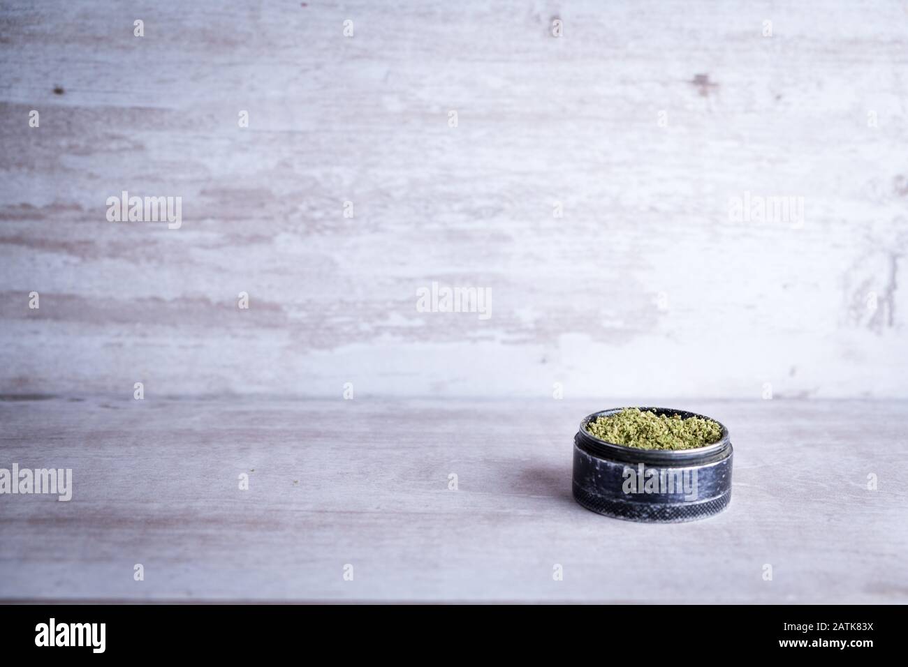 Marihuana recreativa y molino de metal en un fondo de piedra blanca después de que Illinois pasa una ley para legalizar las ventas de malezas y perdón prisión relacionada con malezas Foto de stock