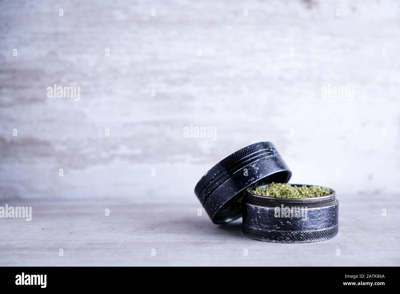 Marihuana recreativa y molino de metal en un fondo de piedra blanca después de que Illinois pasa una ley para legalizar las ventas de malezas y perdón prisión relacionada con malezas Foto de stock