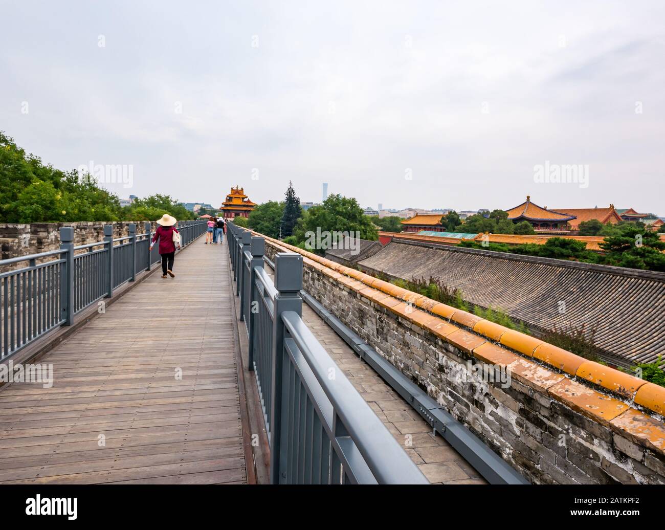 Mujer China que lleva sombrero de paja caminando a lo largo de la pared del palacio con Torre de esquina, Ciudad Prohibida, Beijing, China, Asia Foto de stock