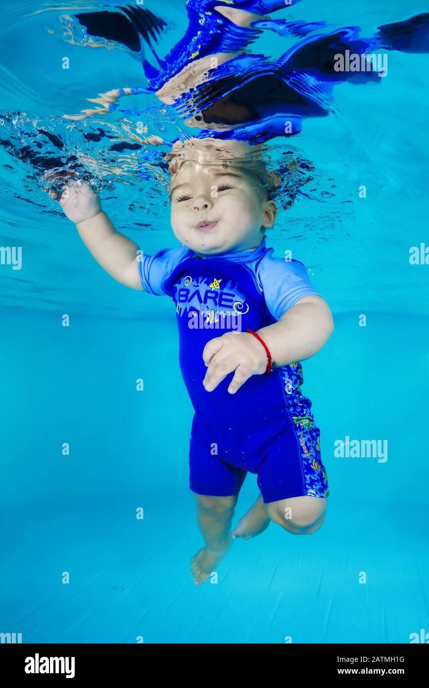 un niño en traje de buceo aprende a bucear bajo el agua en una piscina  Fotografía de stock - Alamy