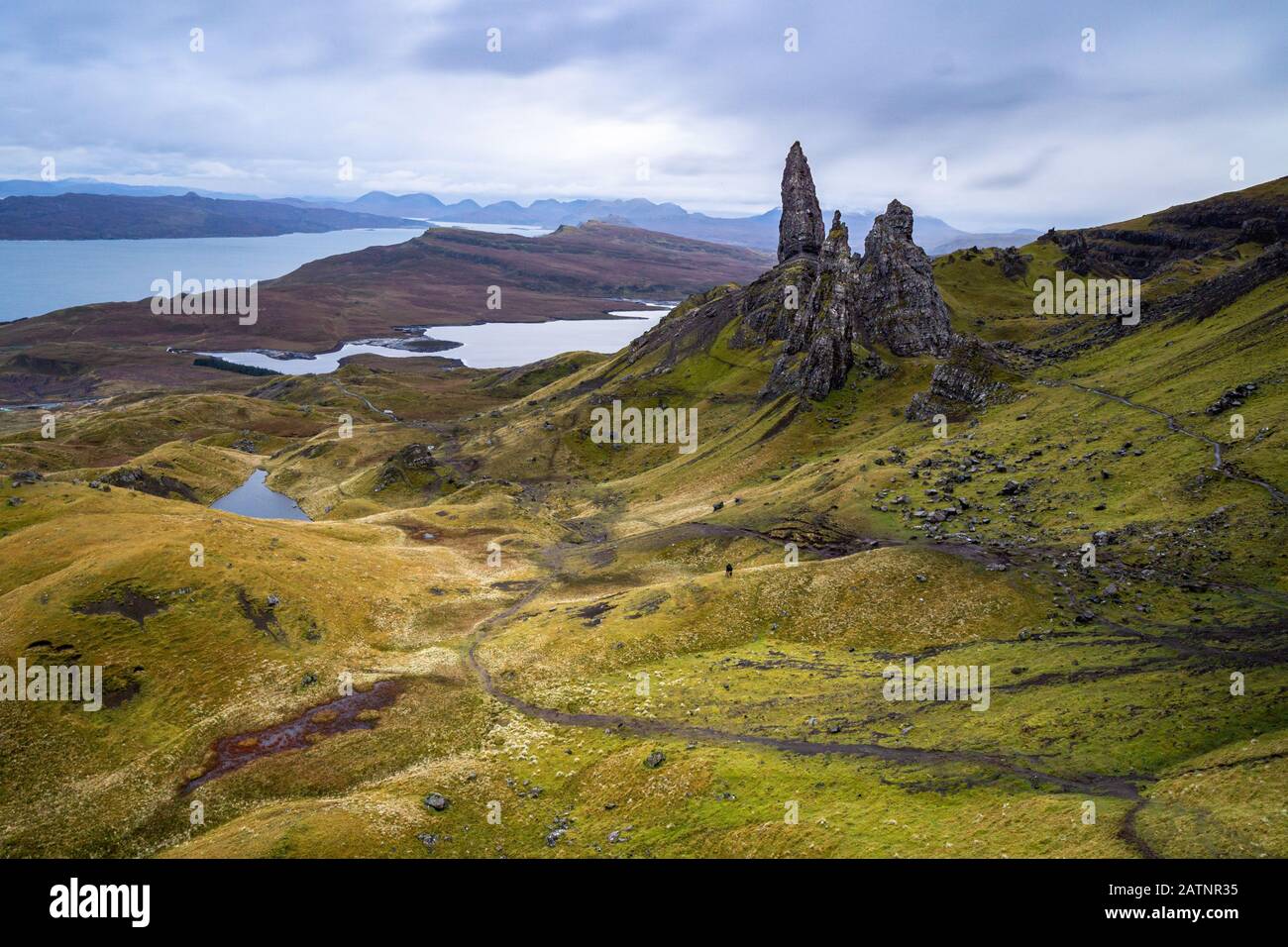 El famoso Viejo Hombre de Storr en Skye es simplemente formidable. La silueta de las dos personas en el centro de la imagen muestra la magnitud de las rocas. Foto de stock