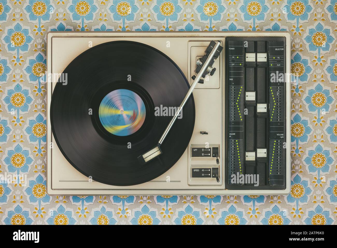 Imagen de estilo retro de un viejo reproductor de discos en la parte superior del fondo de pantalla de flores Foto de stock