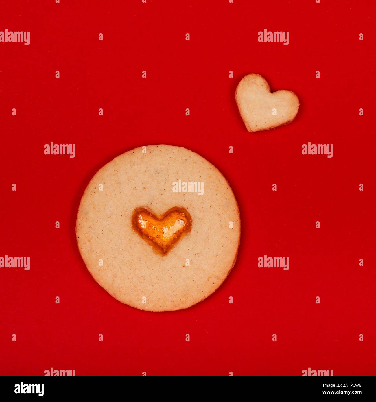 Galletas hechas a mano en forma de corazón sobre fondo rojo. Concepto del día de San Valentín, sorpresas con amor, vacaciones, etc. plano. Foto de stock