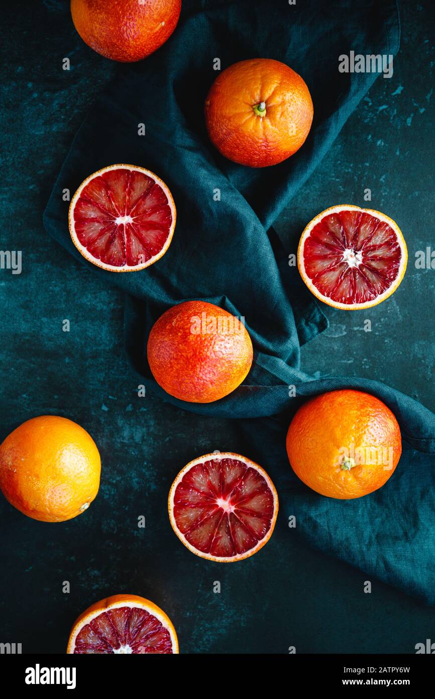 Composición plana de los alimentos con naranjas de sangre sobre un fondo azul oscuro. Foto de stock