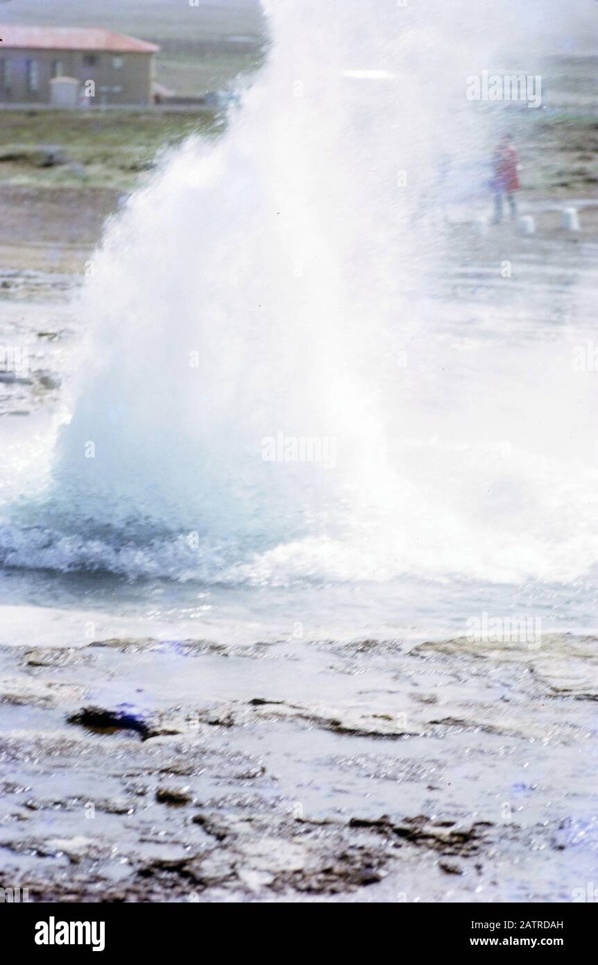 Fotografía vernácula tomada en una transparencia de película analógica de 35 mm, que se cree que representa géiser en arena marrón durante el día, 1970. Entre los principales temas/objetos detectados se incluyen la onda, el agua, el mar, el océano y el géiser. () Foto de stock