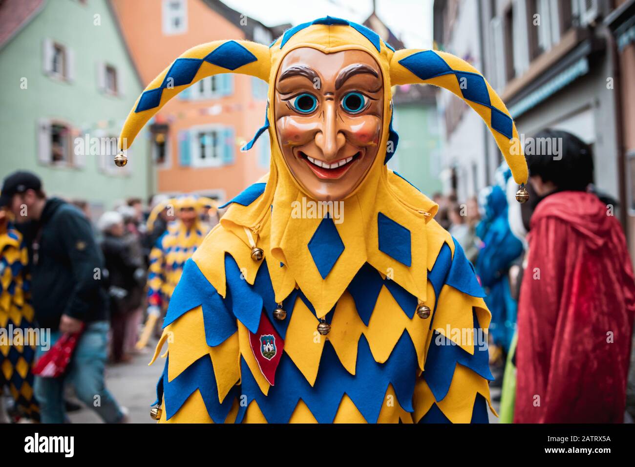 Bajass de Waldkirch - hermosa figura tonta en un manto amarillo-azul con una curiosa expresión en el desfile de carnaval en Staufen, al sur de Alemania Foto de stock