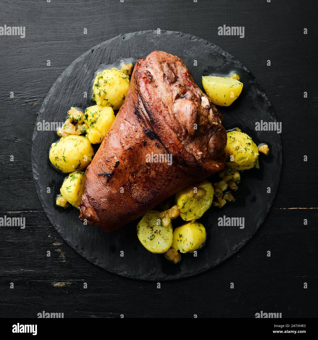 Pierna de cerdo al horno con patatas en un plato de piedra negro. Filete de  pimienta. Vista superior, espacio libre para el texto. Estilo rústico  Fotografía de stock - Alamy