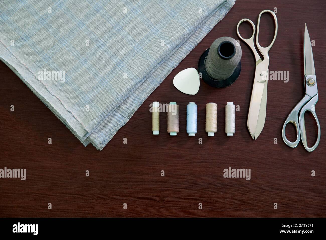 Grupo de objetos de costura tumbados sobre fondo negro de pizarra. Fondo horizontal para anuncios o embalajes. Foto de stock