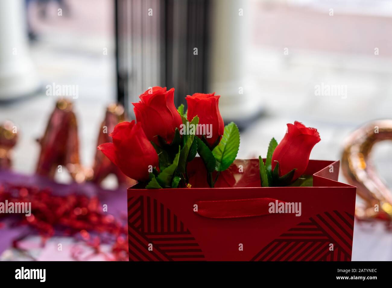 Rosas rojas en una bolsa roja lista para los días de San Valentín Foto de stock