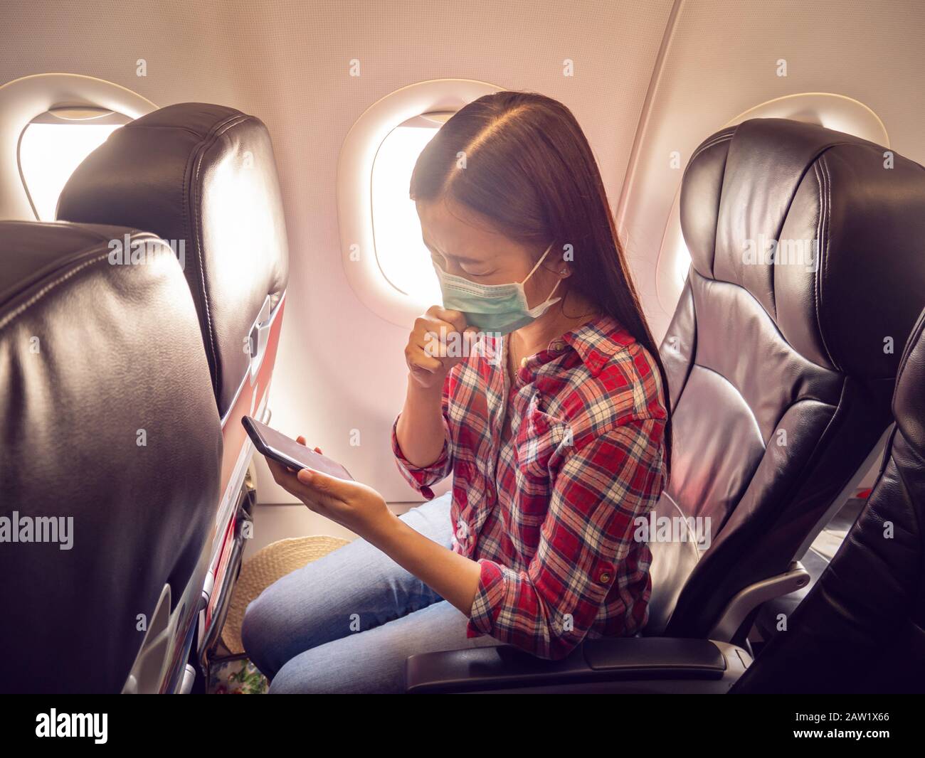 Turista asiático se siente enfermo, tosiendo, usando máscara para prevenir durante el tiempo de viaje en avión para proteger de la nueva infección Coronavirus 2019 outbr Foto de stock
