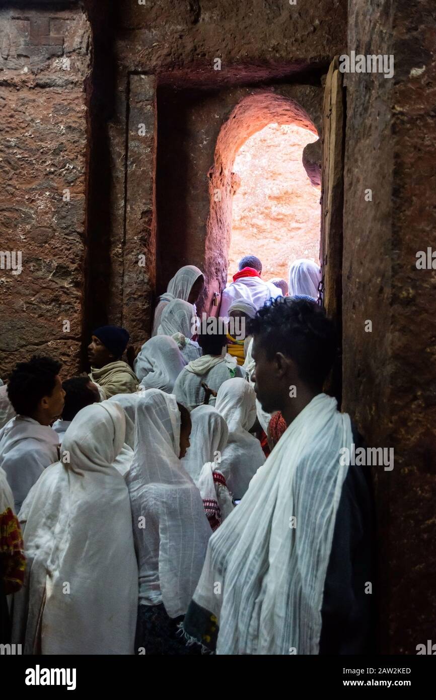 Lalibela, Etiopía - Nov 2018: Peregrinos vestidos con colores blancos tradicionales etíopes reunidos en las iglesias subterráneas de Lalibela. Foto de stock