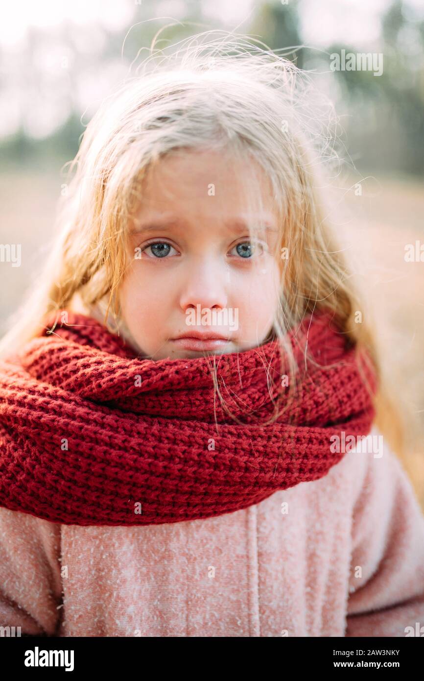 Retrato de una niña en una bufanda con expresión resentida y lágrimas en  los ojos Fotografía de stock - Alamy