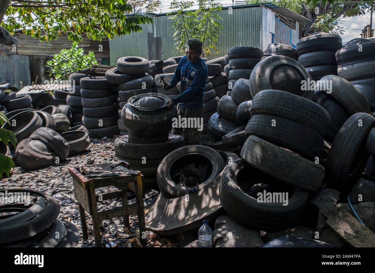 Los trabajadores vieron hacer contenedores de residuos hechos de residuos  de neumáticos usados en el taller "Small and Medium Enterprise" (UKM) en  Palu, Central Sulawesi, Indonesia, el jueves 15 de agosto de