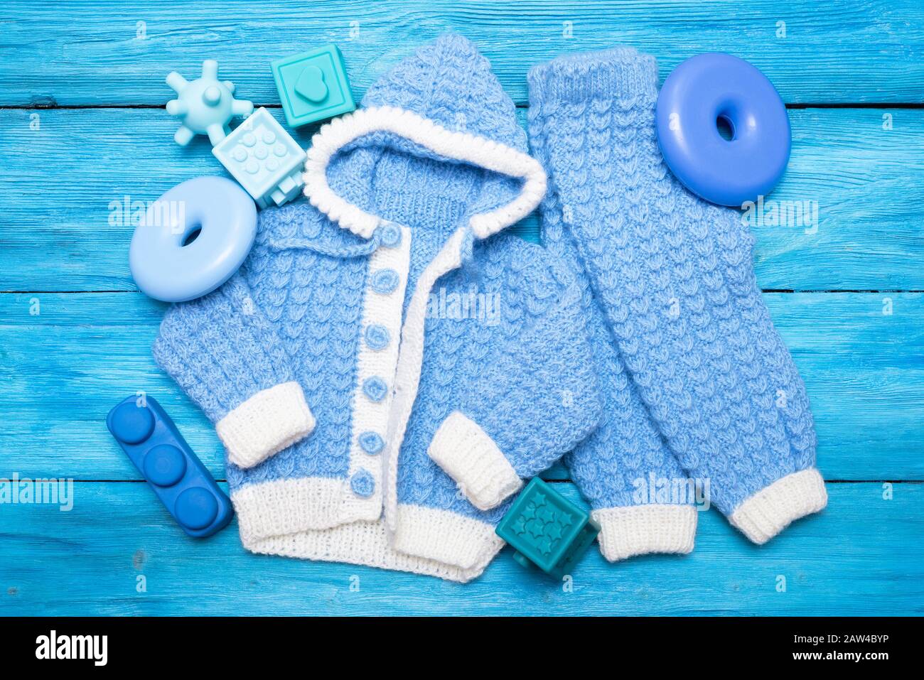 Caliente la ropa de punto para niños y los juguetes para bebés sobre fondo  azul Fotografía de stock - Alamy