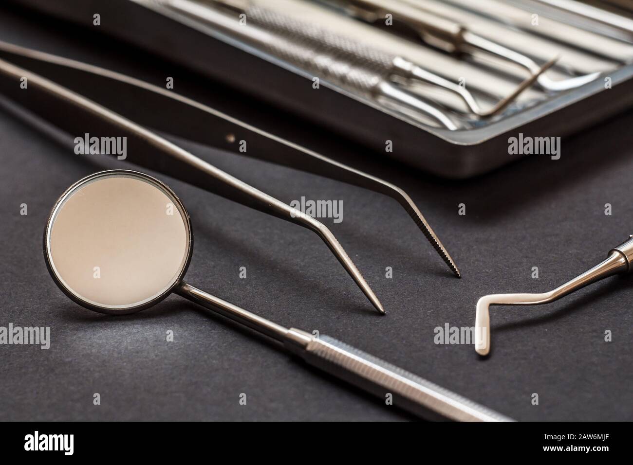 Conjunto de instrumentos metálicos para el tratamiento dental. Espejo de boca, pinzas y raspador de dientes. Herramientas médicas y bandeja de acero inoxidable Vista de primer plano. Shal Foto de stock