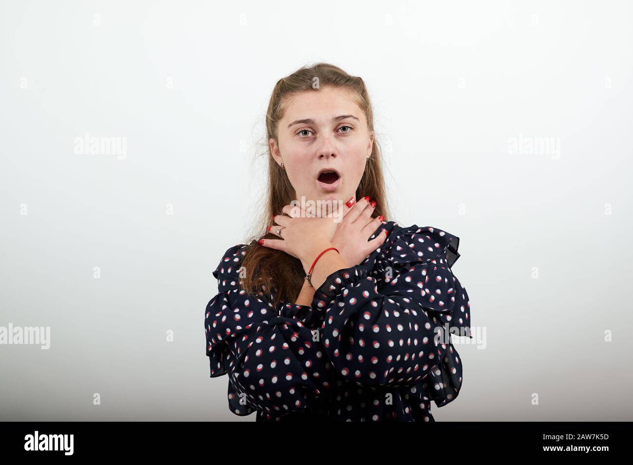 una niña de vestido negro con círculos blancos sostiene sus manos alrededor  del cuello Fotografía de stock - Alamy