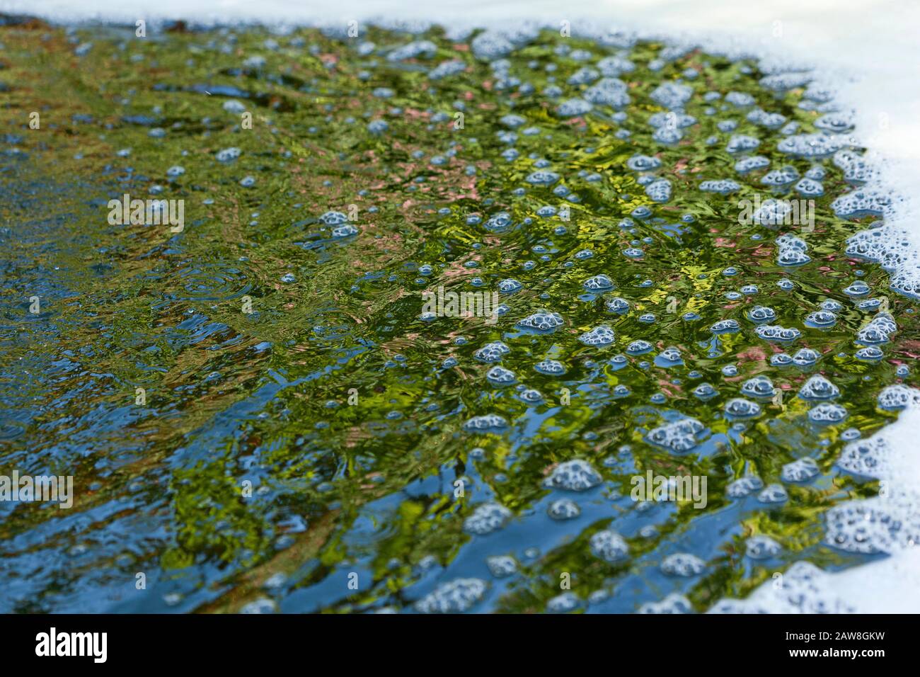 Burbujas, ondulaciones, espuma y reflejos en el agua Foto de stock