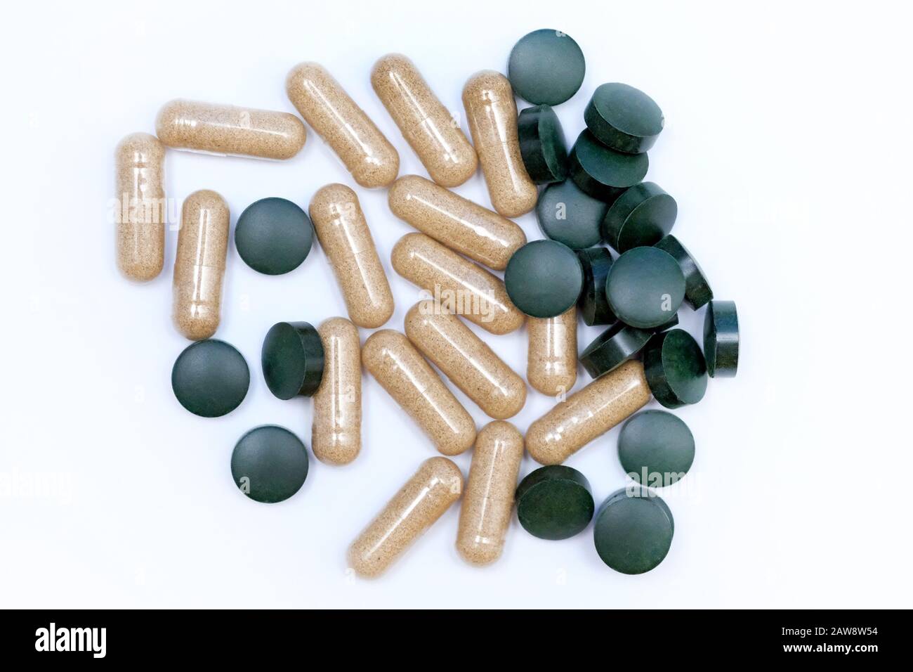Pastillas redondas verdes y cápsulas vista superior. Suplementos alimenticios en tabletas. Cápsulas de Aloe y clorella en tabletas de fondo blanco. El uso de algas Foto de stock