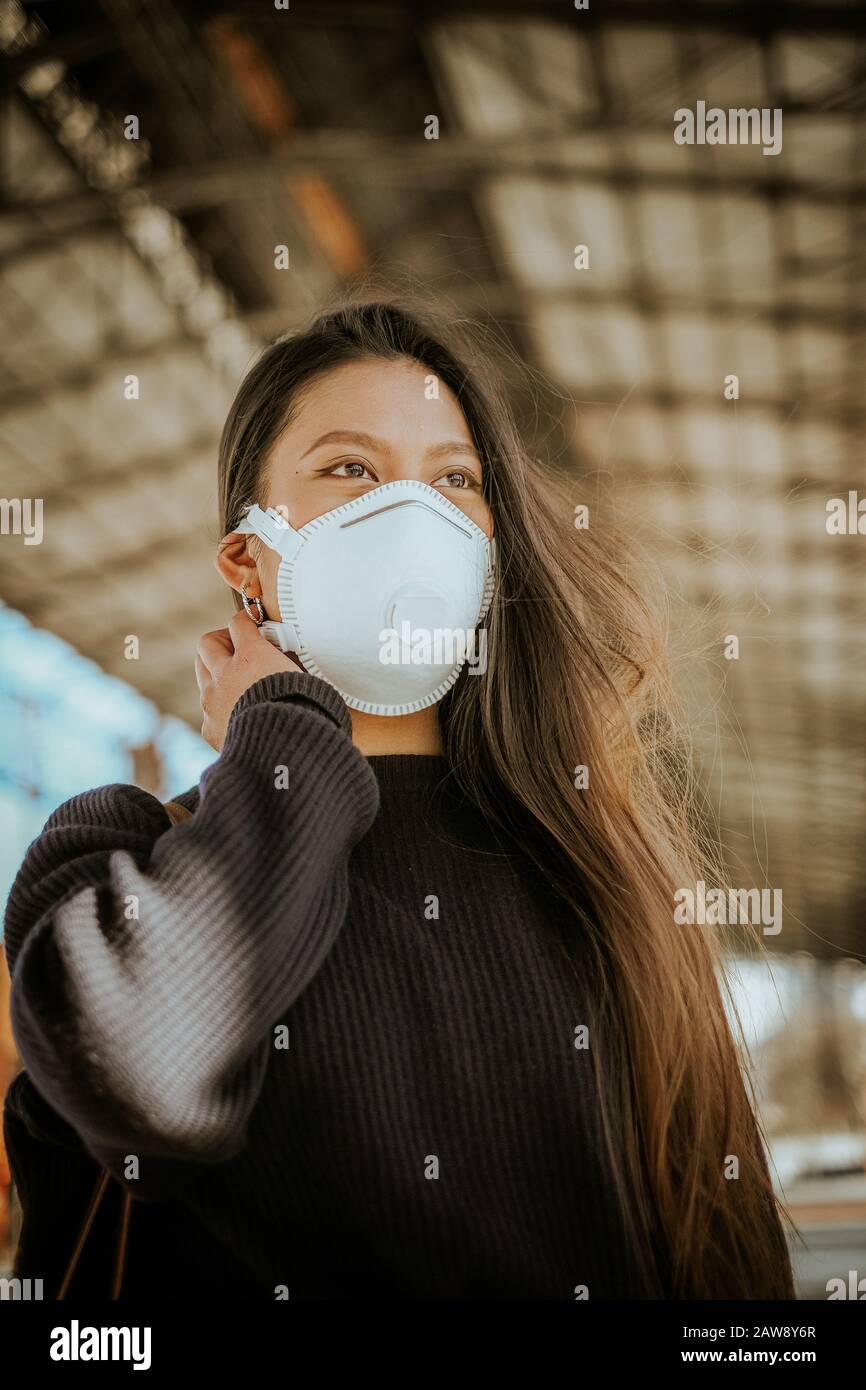Una mujer china con máscara respiratoria para evitar el peligro de infección Foto de stock