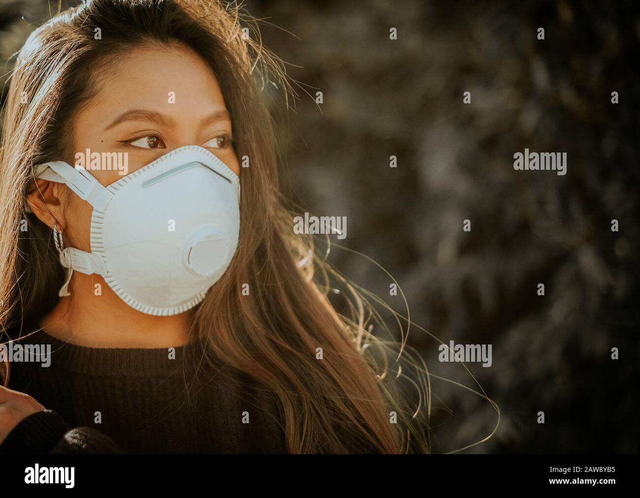 Una mujer china con máscara respiratoria para evitar el peligro de infección Foto de stock