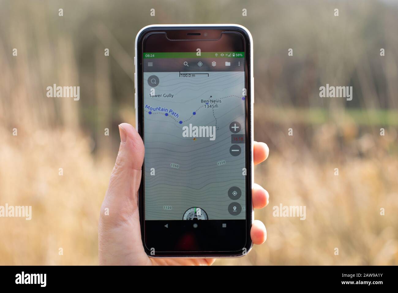 Mapa Thunderforest de Ben Nevis mostrado en un teléfono móvil con césped de invierno en el fondo Foto de stock