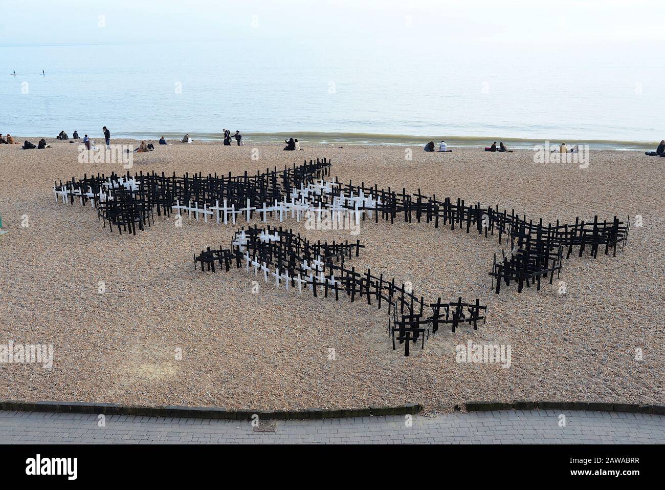 Brighton, Reino Unido, 10 de marzo de 2015. Cientos de estacas de madera pintadas en blanco y negro con forma de cruces están dispuestas en un guijarros en la playa de Brighton en forma de una ballena asesina y es un becerro en esta instalación de arte titulada “Graveyard de ballenas - poniendo espíritus cautivos libres”. La gigantesca pieza de arte, creada para coincidir con el festival WhaleFest de 2015, contó con 1,500 cruces. Cada cruz representa una ballena o un delfín que ha muerto en cautiverio. Foto de stock