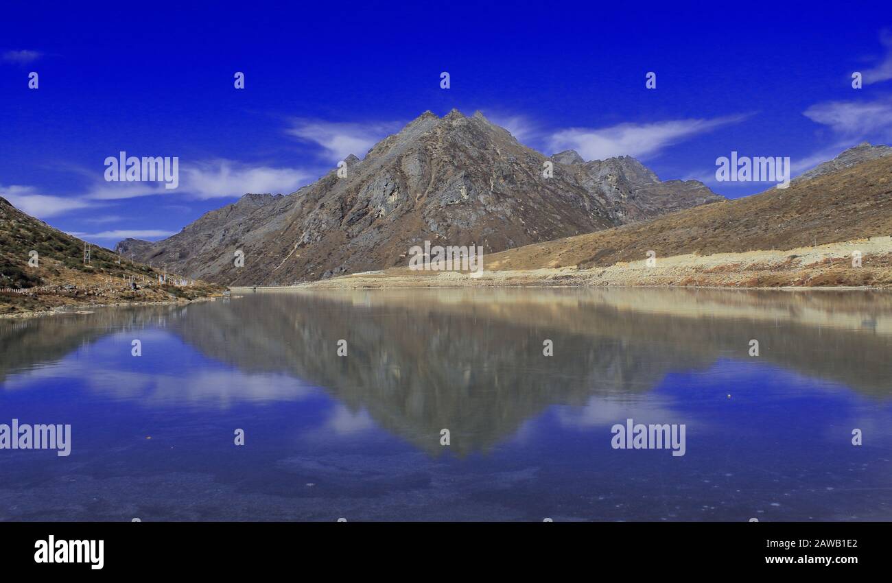 paisaje escénico y reflejo del cielo azul y pico en el lago congelado sela en tawang en arunachal pradesh, india Foto de stock