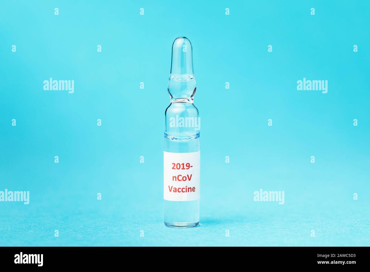 Ampolla de vidrio con vacuna contra nuevo tipo de coronavirus 2019-nCoV sobre fondo azul Foto de stock