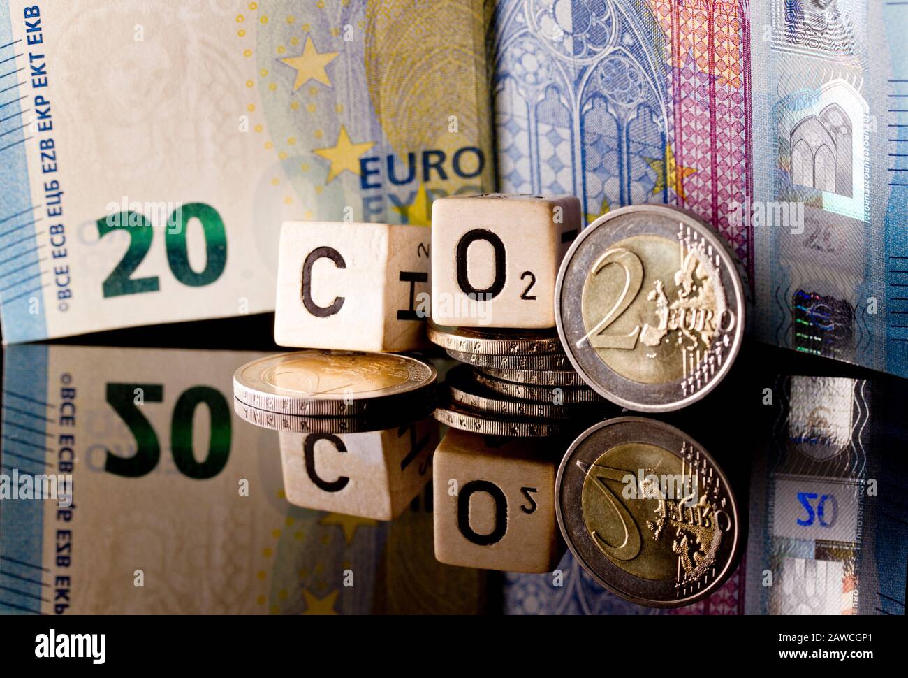CO2-Abgabe und CO2-Steuer, certificados de CO2 simbolizados por dinero, letras y reflejos Foto de stock