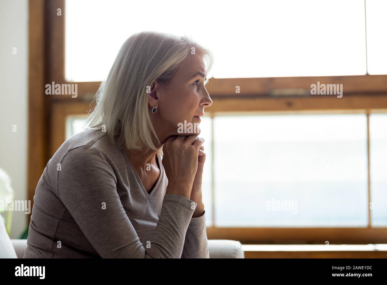 Enojado mujer madura mirar a distancia sintiéndose triste luto Foto de stock