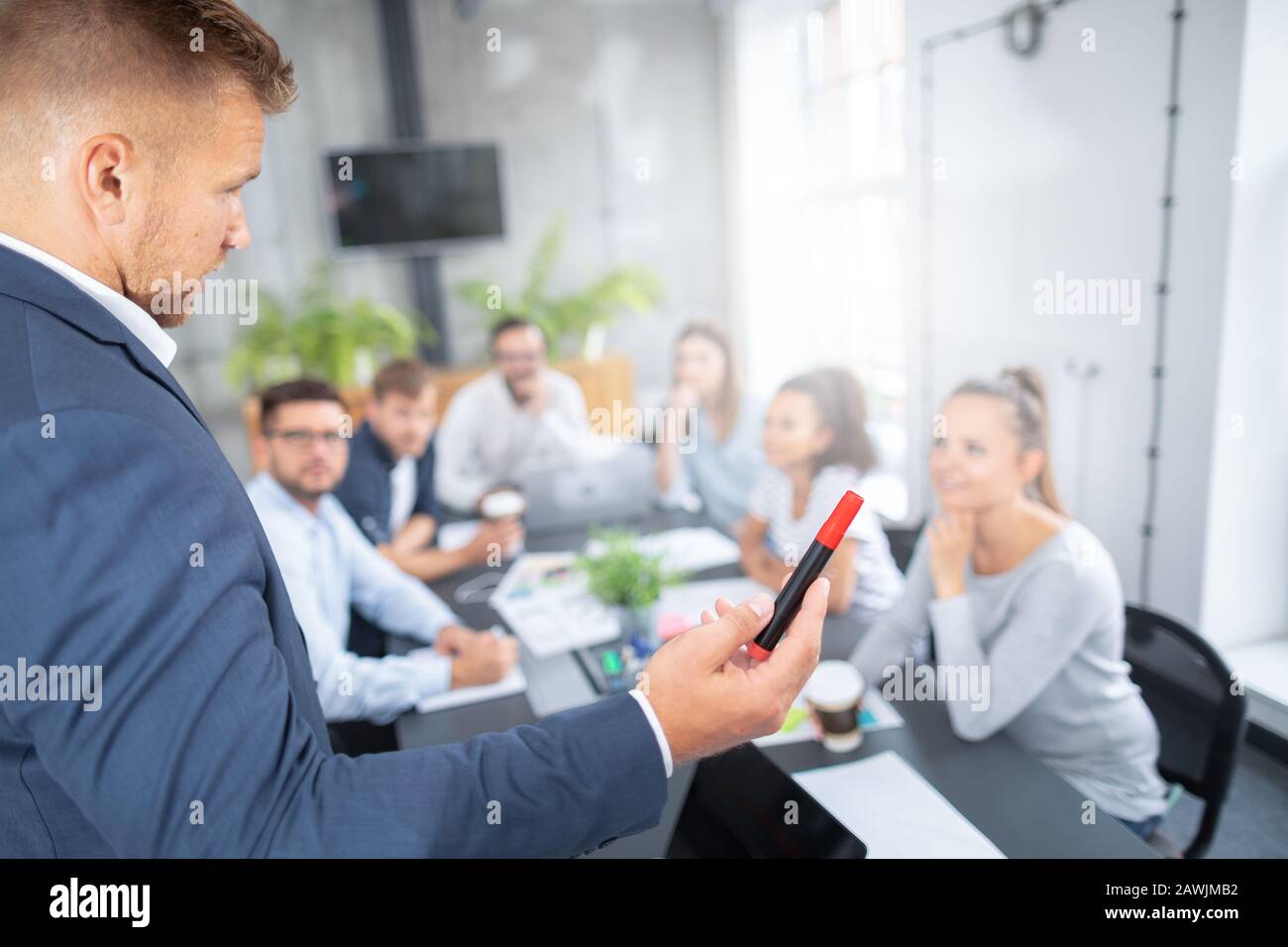 Entrenador de negocios. El líder del equipo enseña a los empleados en una reunión de negocios en una sala de conferencias. Foto de stock