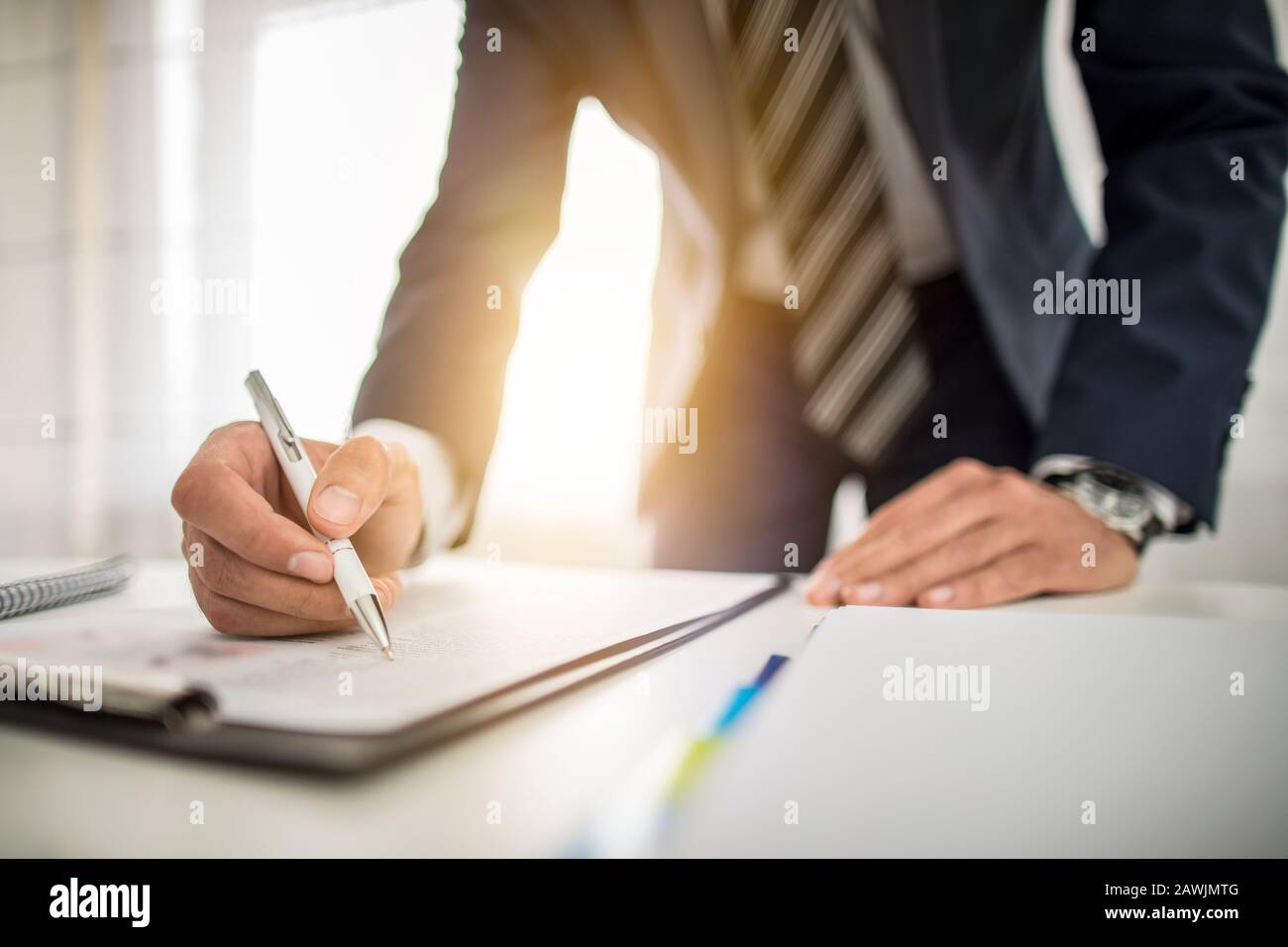 Hombre de negocios firmando el documento de contrato en el escritorio de la oficina, haciendo un trato. Foto de stock