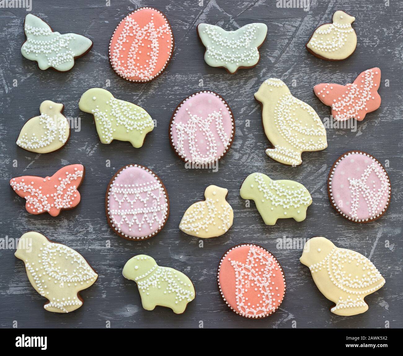 Galletas de pan de jengibre de Pascua decoradas con varios ornamentos sobre un fondo gris. Foto de stock