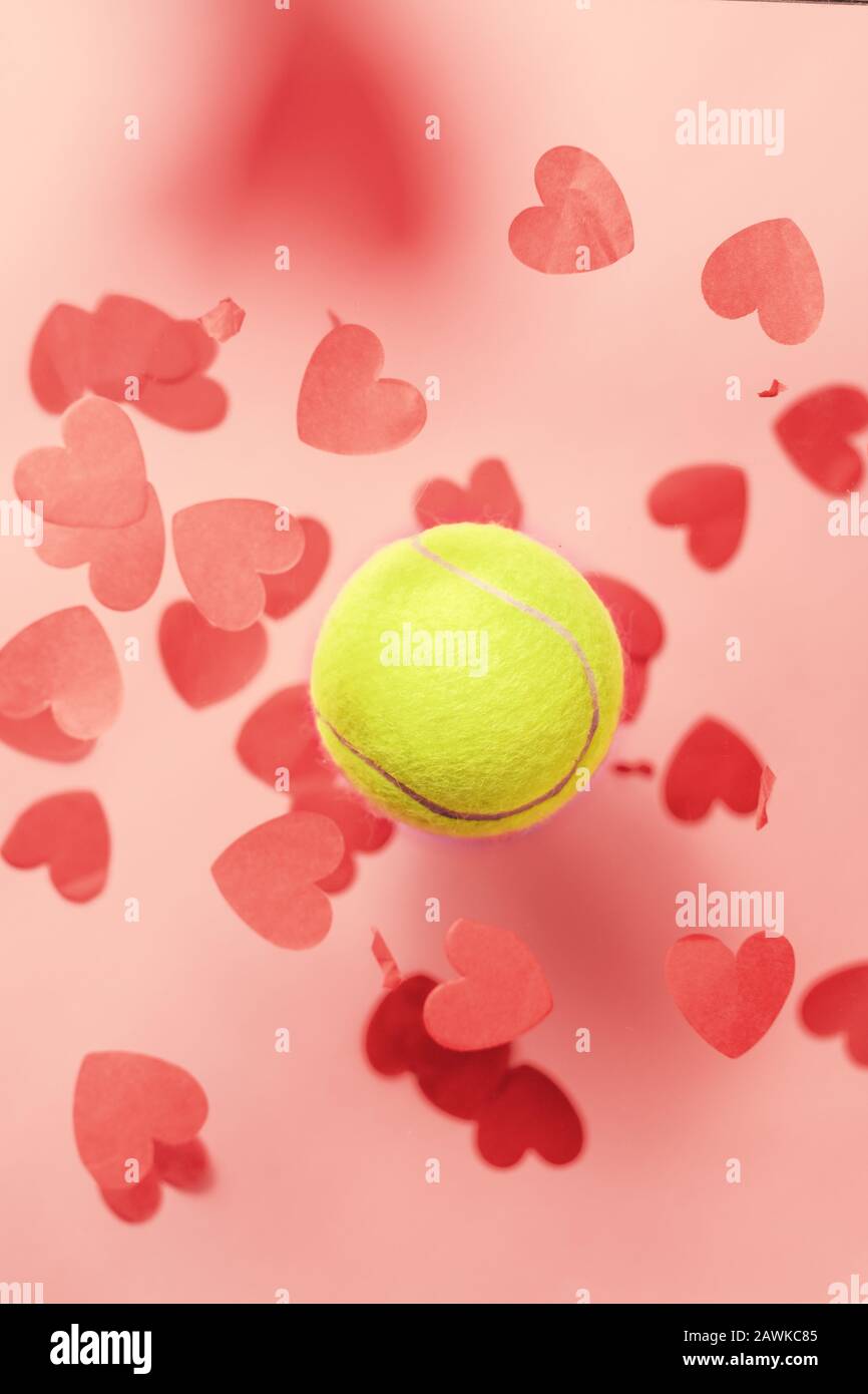 tenis amor diseño pelota de tenis volar corazones confeti. Concepto del día de San Valentín Foto de stock