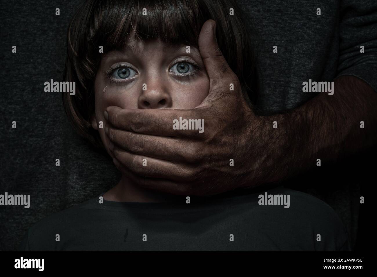 Concepto de abuso infantil. Retrato de un niño asiduo por un adulto agresivo Foto de stock