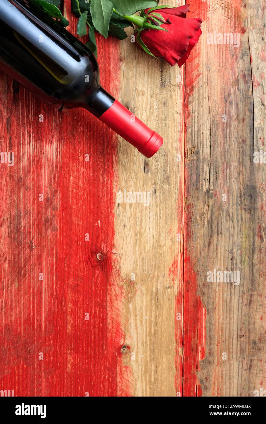 Concepto del día de San Valentín. Botella de vino tinto y una rosa de color  rojo pasión en madera, vista superior Fotografía de stock - Alamy