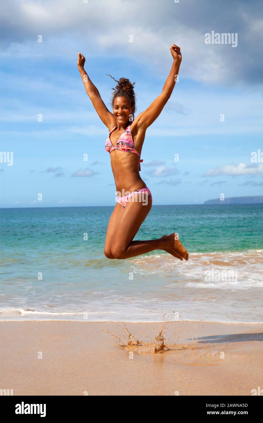 Una mujer mixta salta por la alegría en Big Beach, Makena, Maui, Hawaii  Fotografía de stock - Alamy