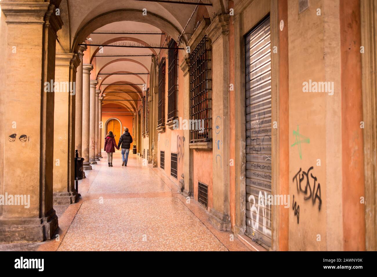 Un par de personas caminando por el sendero cubierto de Bolonia en el centro histórico medieval de la ciudad de Bolonia. Región Emilia-Romagna, Norte De Italia. Foto de stock
