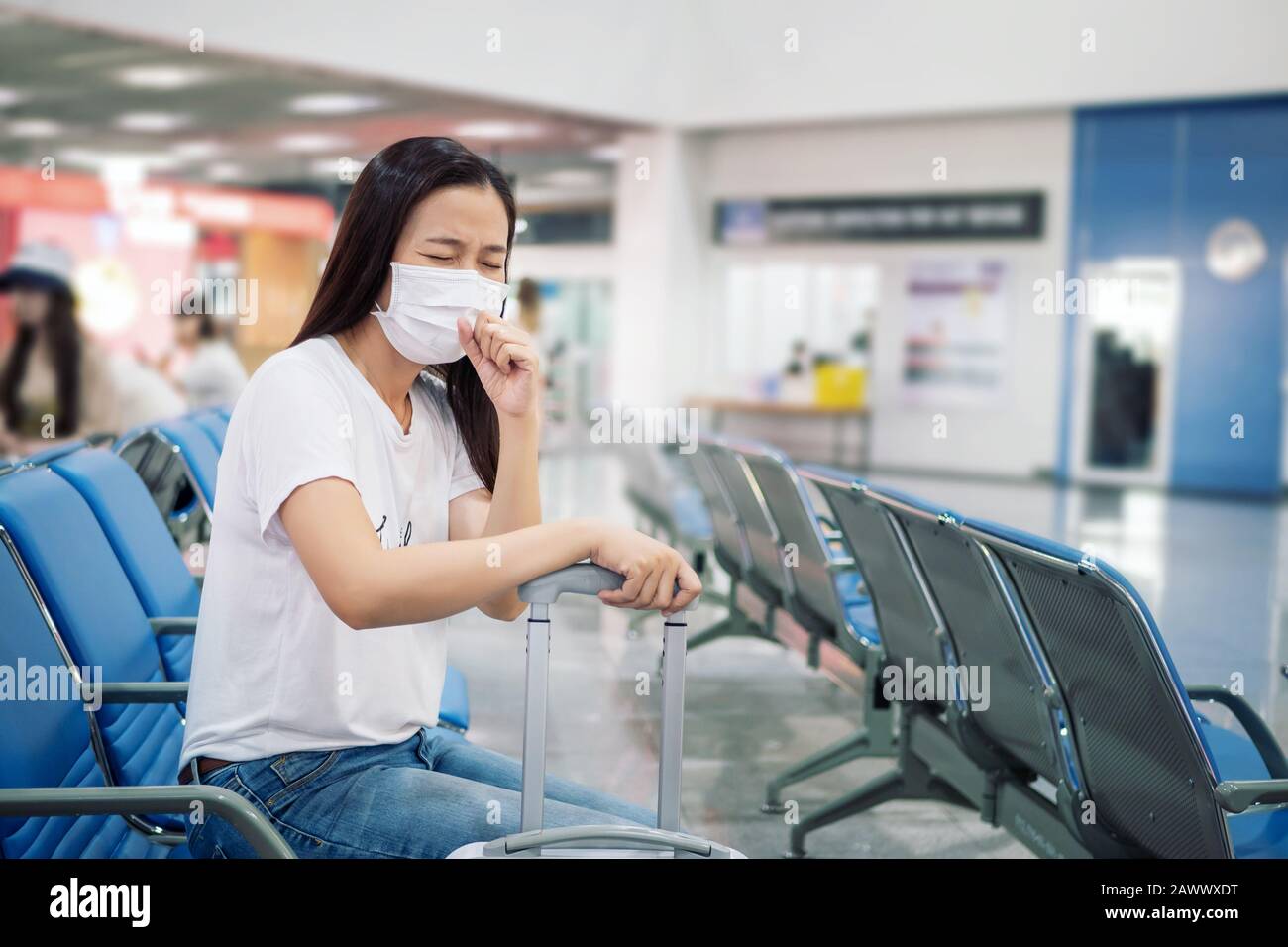 Turista asiático se siente enfermo, tosiendo, usando máscara para prevenir durante el tiempo de viaje en la terminal del aeropuerto para proteger del nuevo Coronavirus 2019 inf Foto de stock