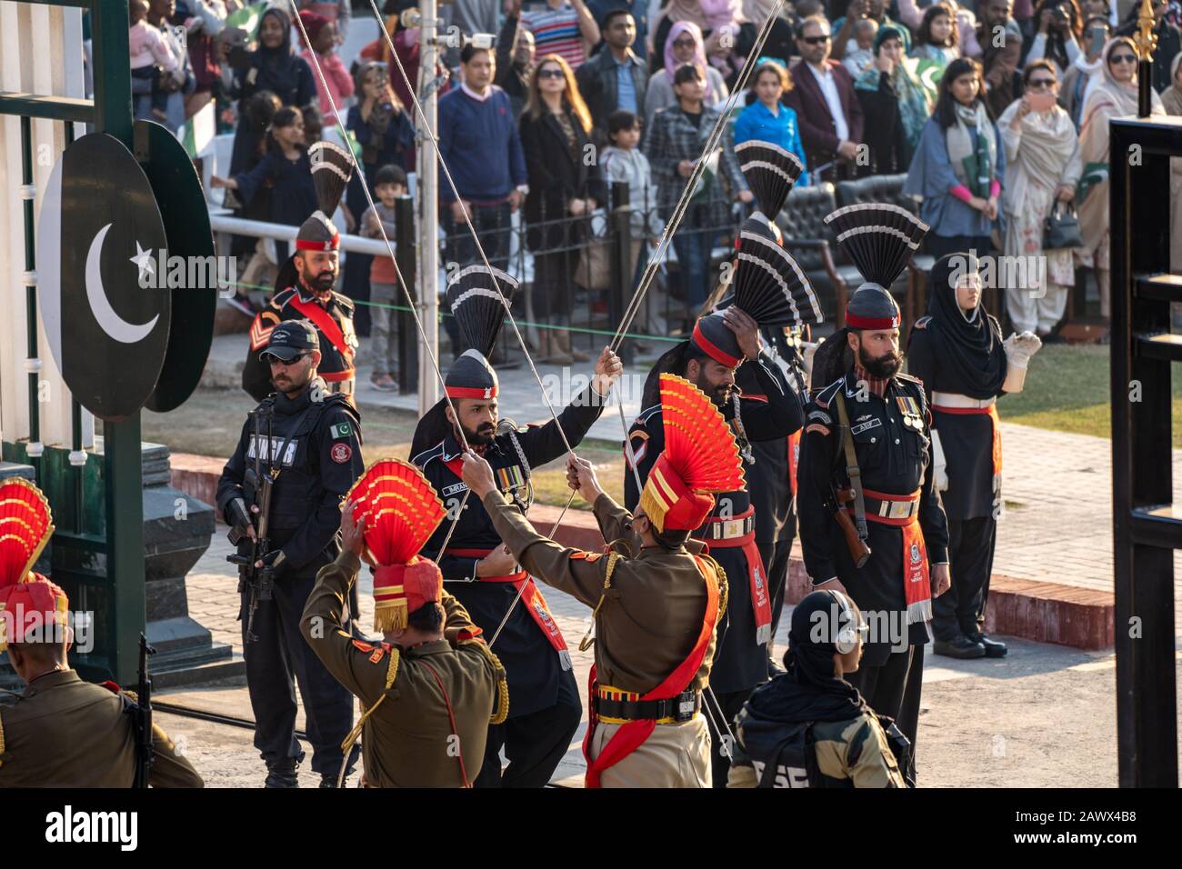 Amritsar India - febrero 8, 2020: La Fuerza de Seguridad Fronteriza India y los Rangers de Pakistán (uniformes negros) bajan las banderas en la ceremonia de clausura de la frontera de Wagah Foto de stock