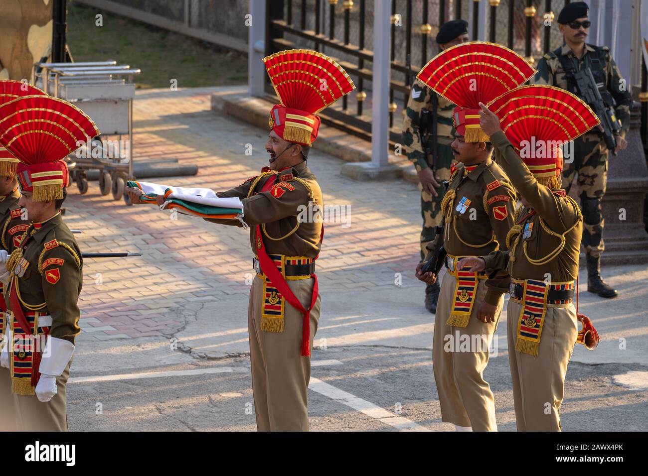 Amritsar, India - febrero 8, 2020: La Fuerza de Seguridad Fronteriza India lleva la Bandera India después de la ceremonia de cierre de la Frontera de Wagah con Pakistán, por e Foto de stock
