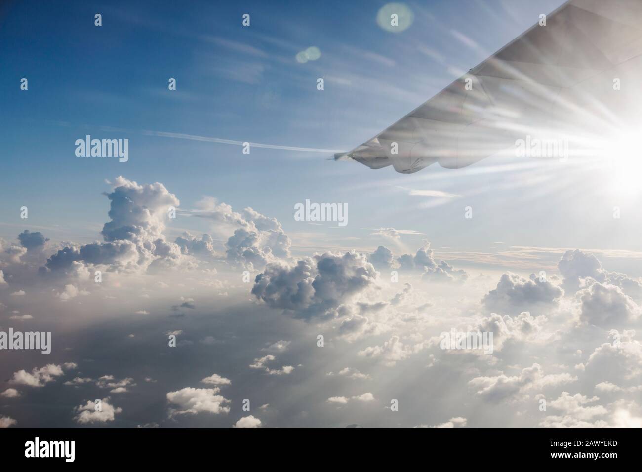 Ala de avión moviéndose a través de un cielo tranquilo, soleado y nublado Foto de stock