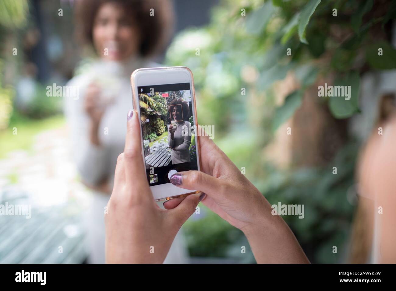 Mujer perspectiva personal con teléfono inteligente fotografiando a un amigo Foto de stock