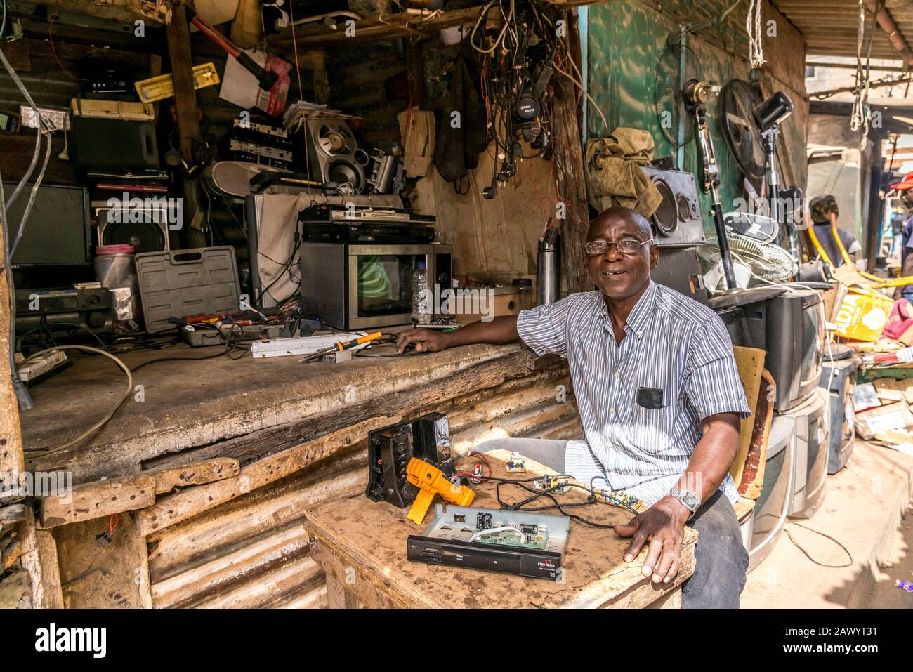 Werkstatt für Elektronik auf dem Markt en Bakau, Gambia, Westafrika | Tienda de reparación de mercado Bakau, Gambia, África Occidental, Foto de stock