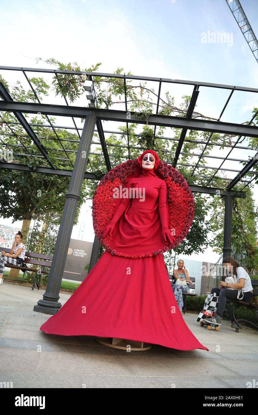 Timisoara, en Rumania- 09.06.2019 Vive la estatua de la Diosa de las rosas.  Vestido de mujer vestida de rojo y con una tapa de Roses se presentan como  un humano realista stat