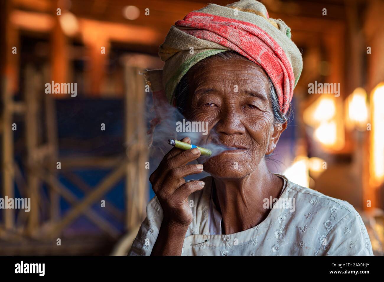Anciana de la minoría étnica Pa'o que fuma un cigarro birmano en la aldea de Indein cerca del lago Inle, estado de Shan, Myanmar (Birmania). Foto de stock