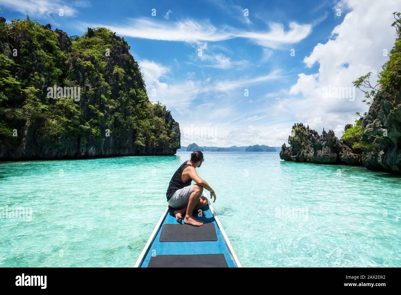 El Nido, Palawan, Filipinas, viajero sentado en la cubierta del barco explorando los lugares naturales alrededor de el Nido en un día soleado. Foto de stock