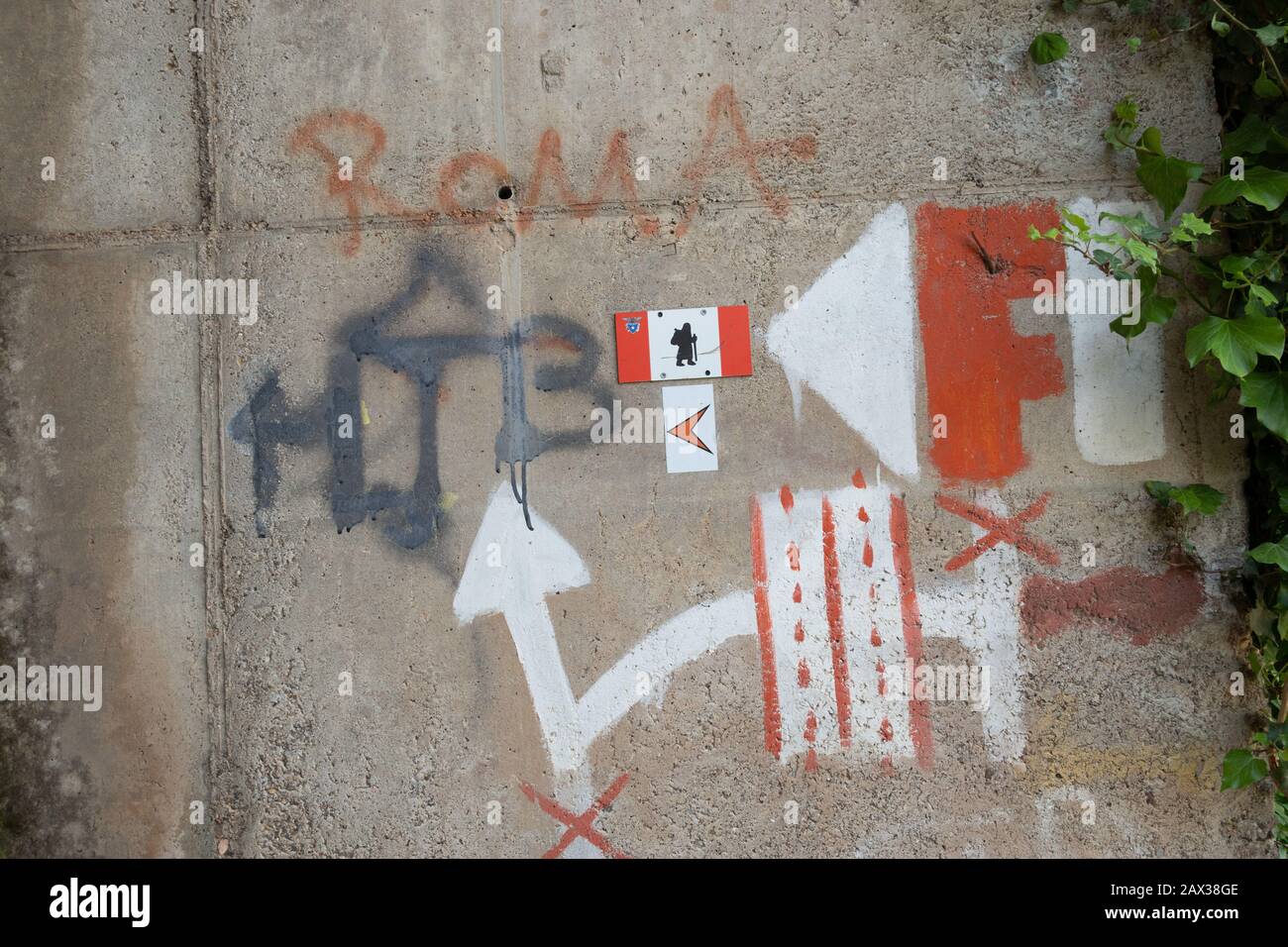 ¿Qué manera de ir instrucciones pintadas en la pared en Italia que guía a los peregrinos y las caminatas la mejor ruta para tomar en la vía Francigena. Vaya por debajo de la carretera Foto de stock